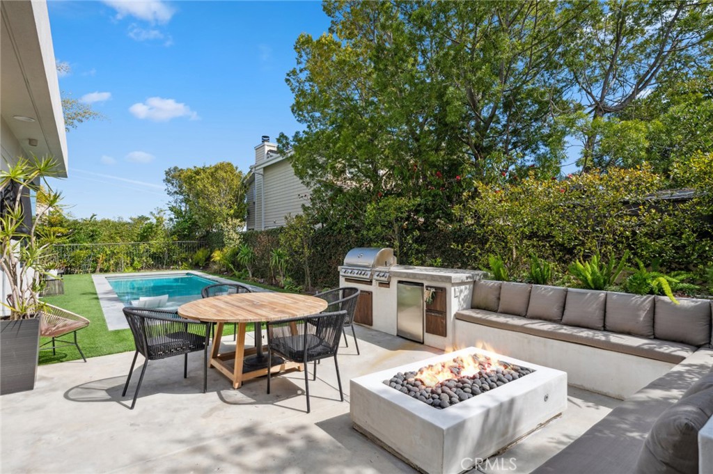 2831 Ridge Drive Laguna Beach, CA 92651 - Photo 11 of 21 a view of a patio with a dining table and chairs with a fire pit