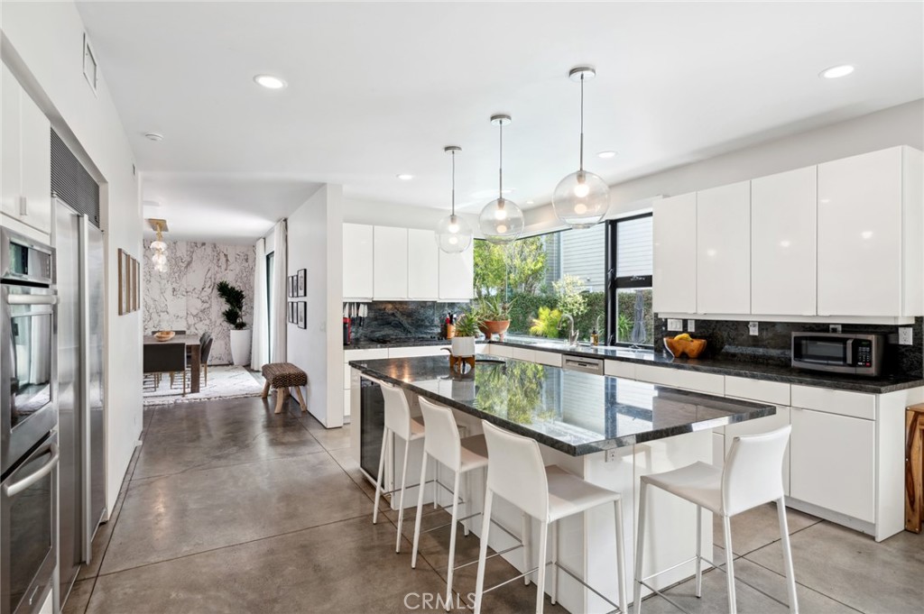 2831 Ridge Drive Laguna Beach, CA 92651 - Photo 13 of 21 a kitchen with stainless steel appliances granite countertop a stove a sink a refrigerator and white cabinets with wooden floor
