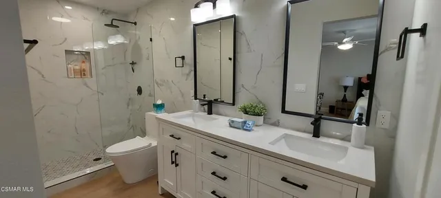 a bathroom with a double vanity sink toilet and shower