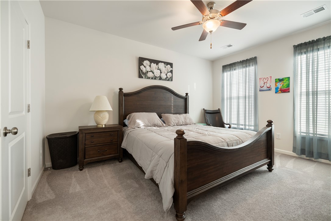 104 Village Main Anderson, SC 29621 - Photo 14 of 30 This inviting bedroom features soft carpeting, ample natural light, and a functional ceiling fan.