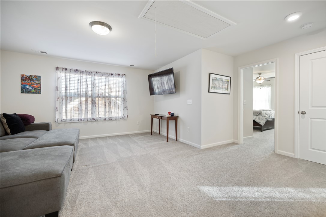 104 Village Main Anderson, SC 29621 - Photo 18 of 30 This flexible living space features soft carpeting, a bright window, and an accessible attic entrance.