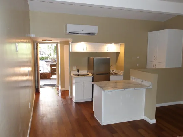 a kitchen with granite countertop cabinets and wooden floor