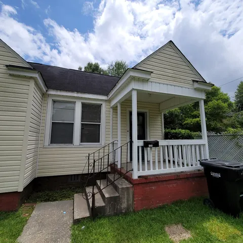 a view of a house with a wooden deck and a yard