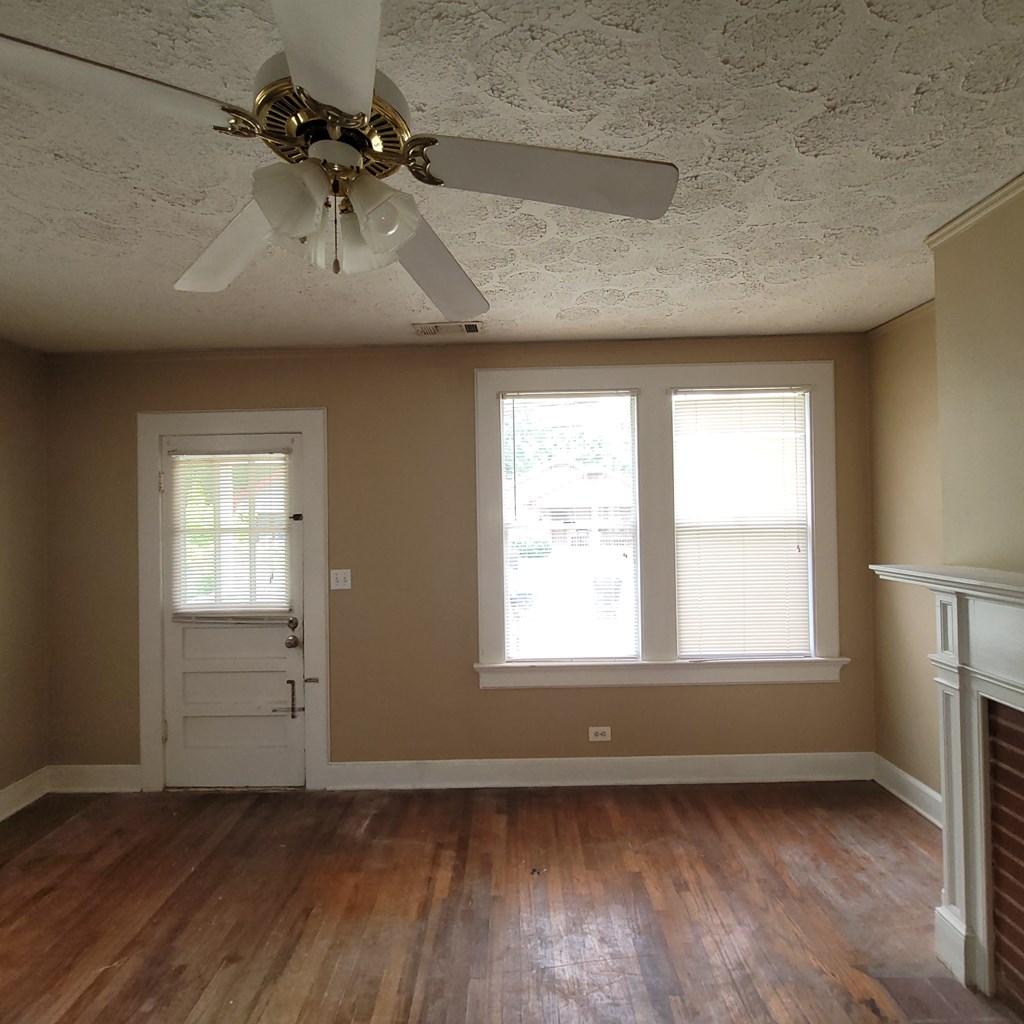 2220 Bell Street Columbus, GA 31906 - Photo 4 of 11 an empty room with wooden floor cabinet and windows