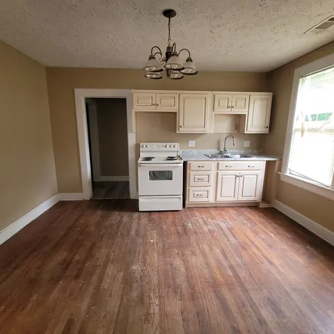 a kitchen with stainless steel appliances granite countertop a stove and a wooden floors