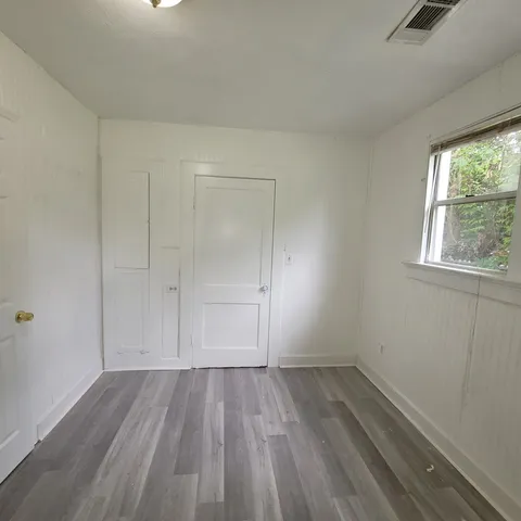 an empty room with a hardwood and windows