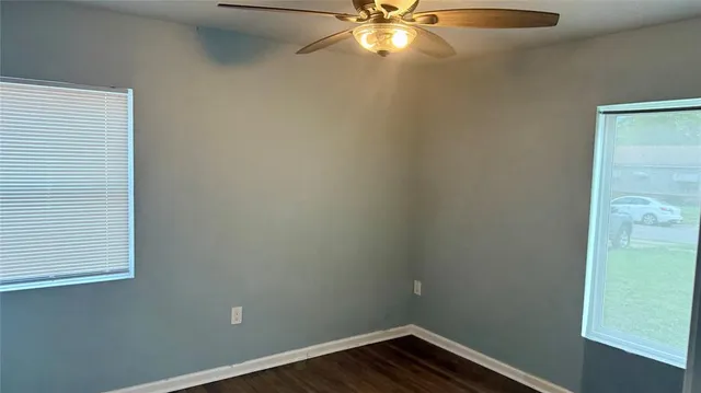 an empty room with a window and wooden floor