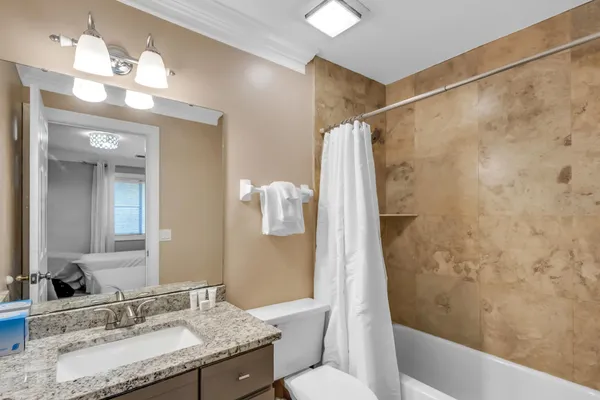 a bathroom with a granite countertop sink toilet and shower