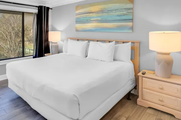 a large bed sitting in a bedroom next to a window