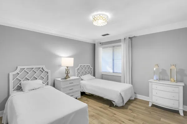 a bedroom with two beds and painting on the wall