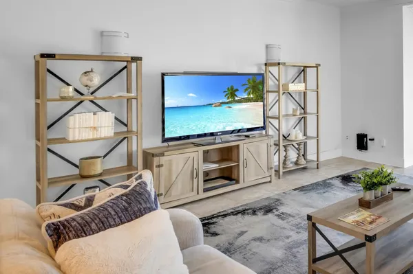 a living room with furniture a flat screen tv and a floor to ceiling window