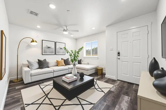 a living room with furniture and wooden floor
