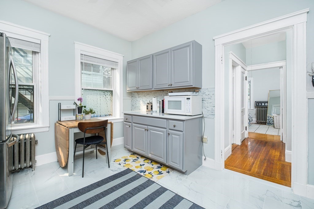108 Washington Street, Unit 8 Boston, MA 02135 - Photo 11 of 18 a kitchen with sink cabinets and dining table