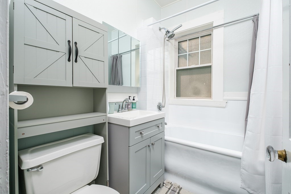 108 Washington Street, Unit 8 Boston, MA 02135 - Photo 12 of 18 a bathroom with a granite countertop sink a toilet and bathtub