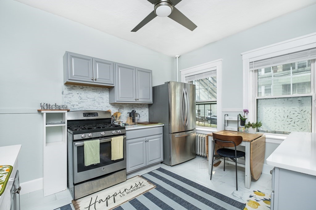 108 Washington Street, Unit 8 Boston, MA 02135 - Photo 8 of 18 a kitchen with stainless steel appliances a stove a sink island and a refrigerator