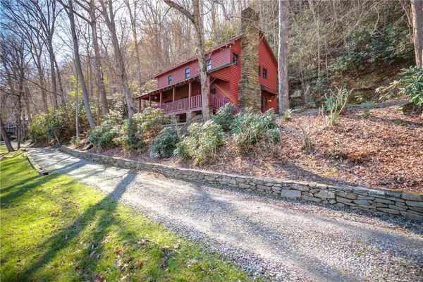 a view of a house with backyard and trees