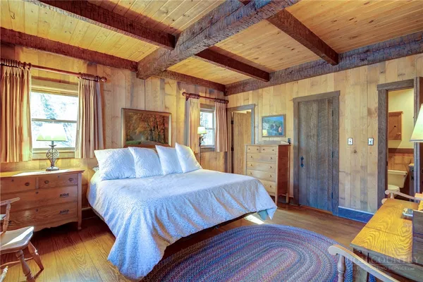 a bedroom with a bed and a dresser next to a window