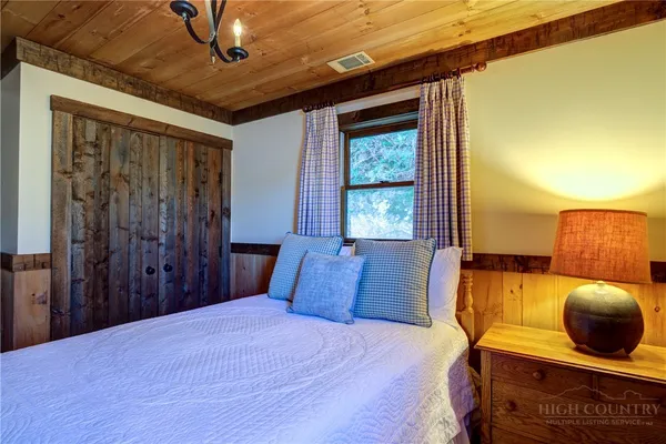 a bedroom with a large bed and wooden floor