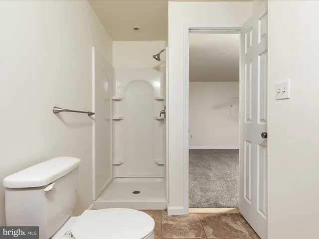 a bathroom with a toilet and a shower