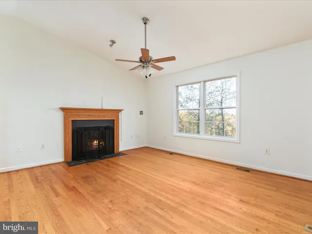 an empty room with fan and windows