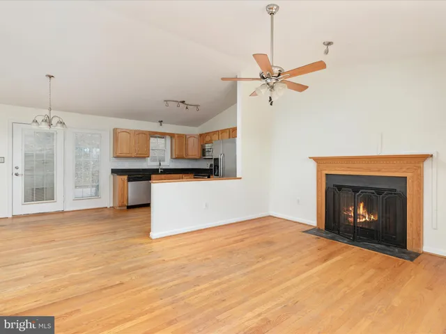 a view of a kitchen an empty room and fire place