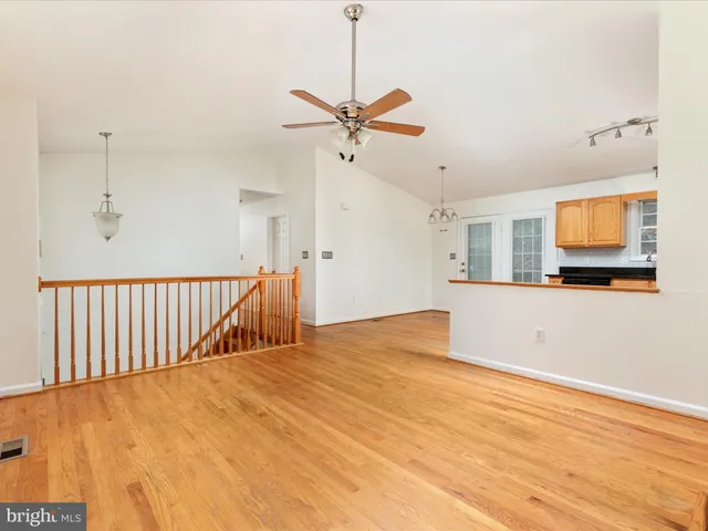 a view of a kitchen with wooden floor and a ceiling fan