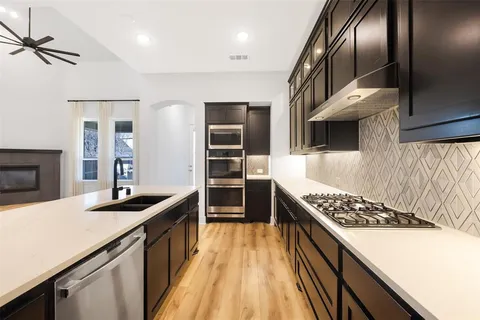 a kitchen with stainless steel appliances granite countertop a sink stove and refrigerator