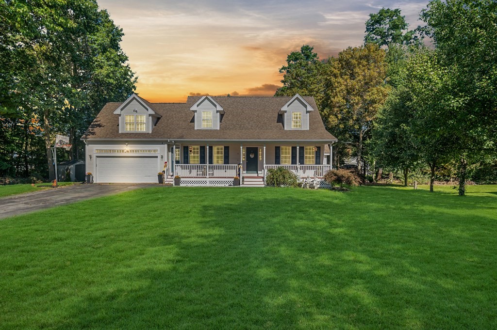 a front view of a house with a yard and trees