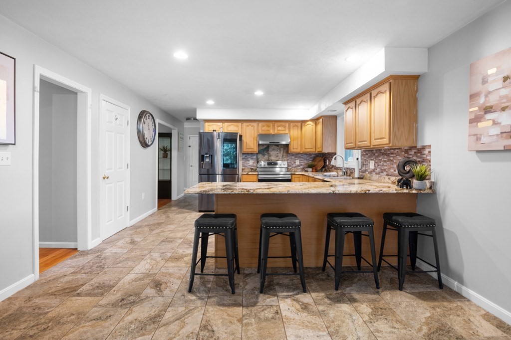 5 Michele Drive Salisbury, MA 01952 - Photo 32 of 38 a dining room with stainless steel appliances kitchen island granite countertop a table chairs a sink and a refrigerator