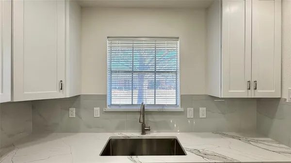 a kitchen with a white cabinets and a window