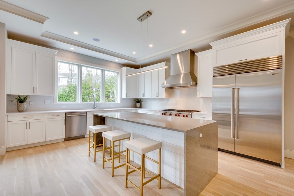 192 Evelyn Road Newton, MA 02468 - Photo 9 of 41 a kitchen with kitchen island white cabinets a sink a stove a refrigerator and wooden floor
