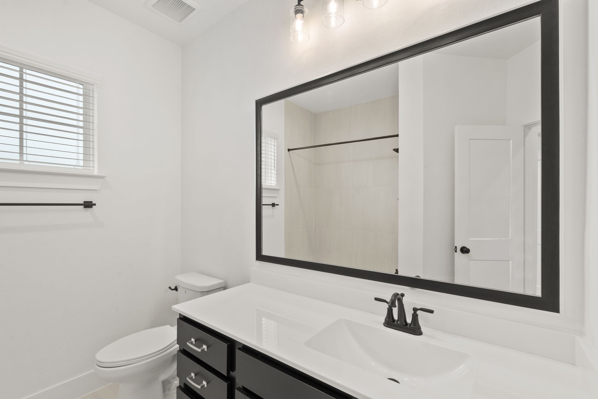 329 Rock Rose Path Willis, TX 77318 - Photo 19 of 36 a bathroom with a sink a toilet and mirror