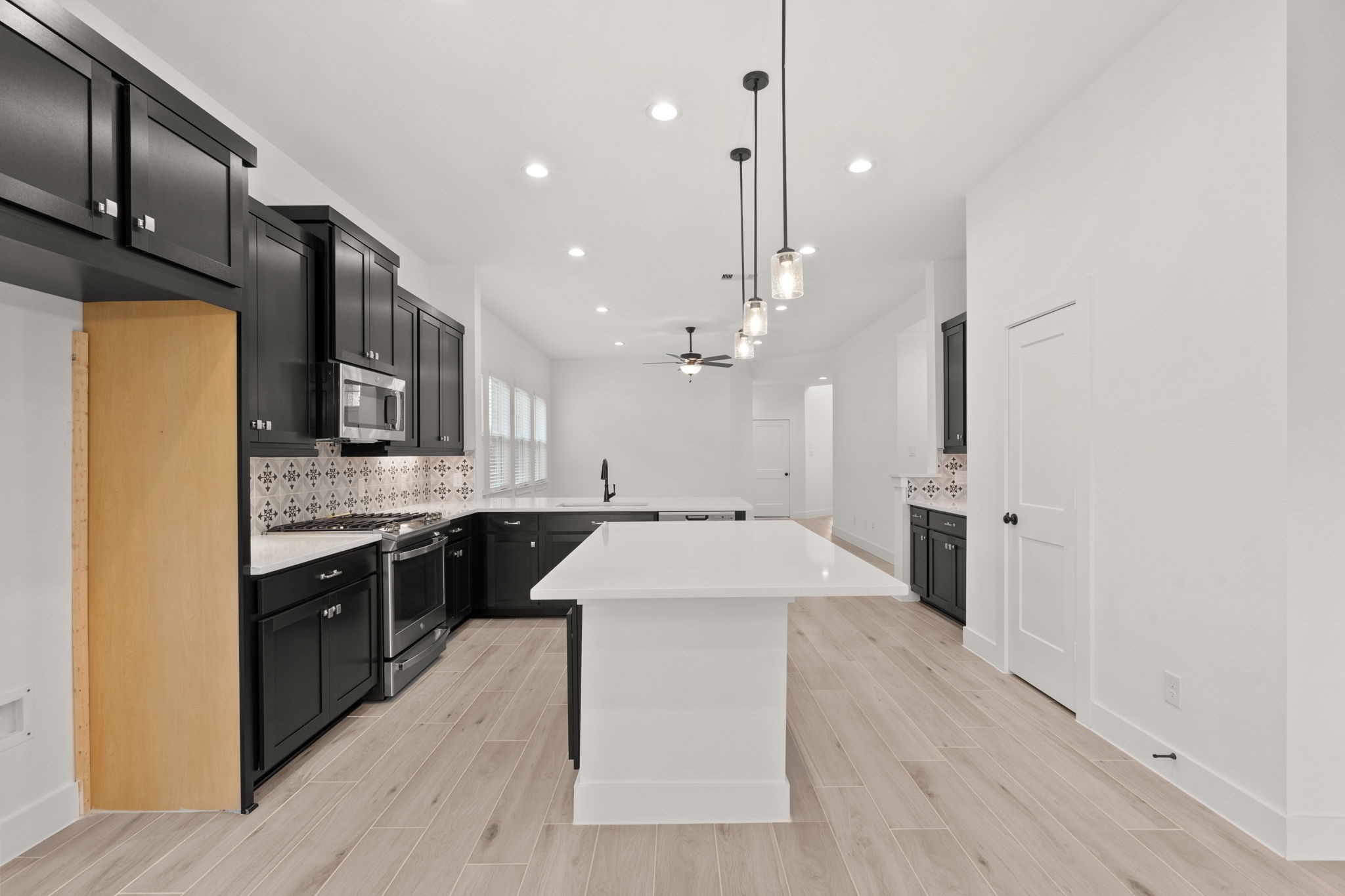 329 Rock Rose Path Willis, TX 77318 - Photo 5 of 36 a large kitchen with stainless steel appliances kitchen island granite countertop a refrigerator a stove a sink and a wooden floors