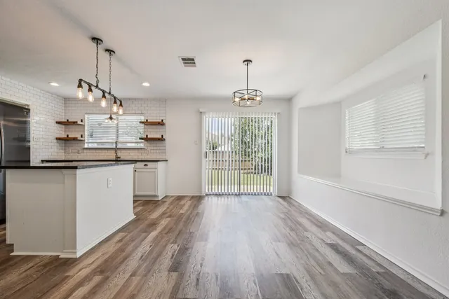 a kitchen with kitchen island granite countertop a sink window and wooden floor