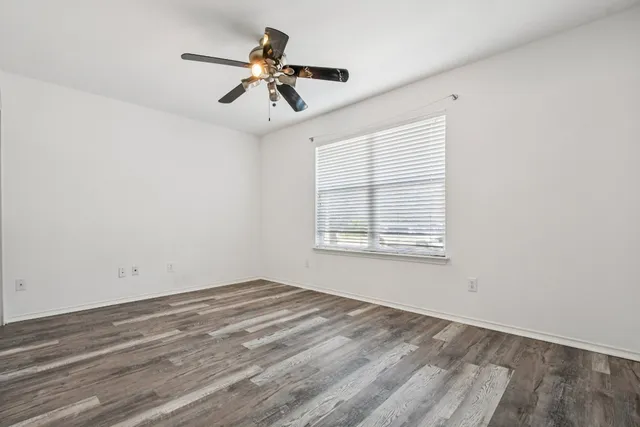 a view of a room with a ceiling fan and wooden floor