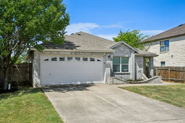 a front view of a house with a garden and trees