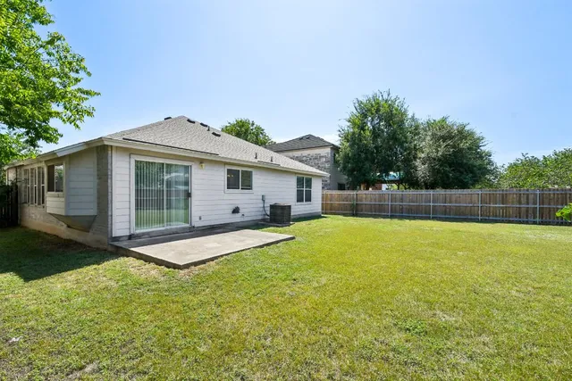 a front view of house with yard and trees in the background
