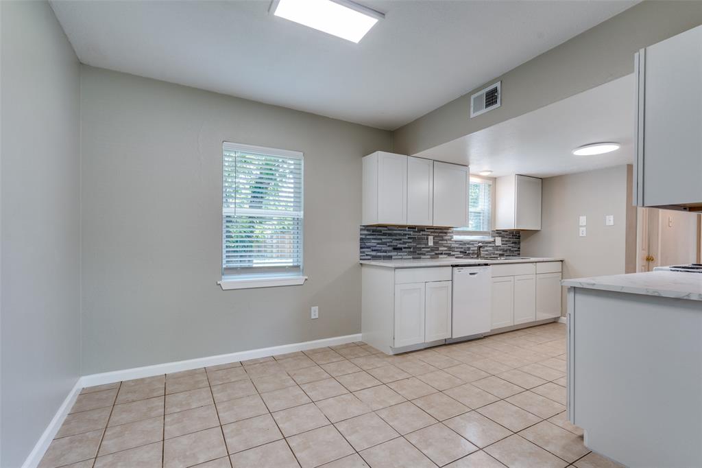 1202 Quill Drive Plano, TX 75075 - Photo 11 of 28 a kitchen with granite countertop white cabinets and white appliances