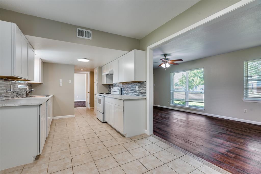1202 Quill Drive Plano, TX 75075 - Photo 12 of 28 a kitchen with a sink cabinets and window