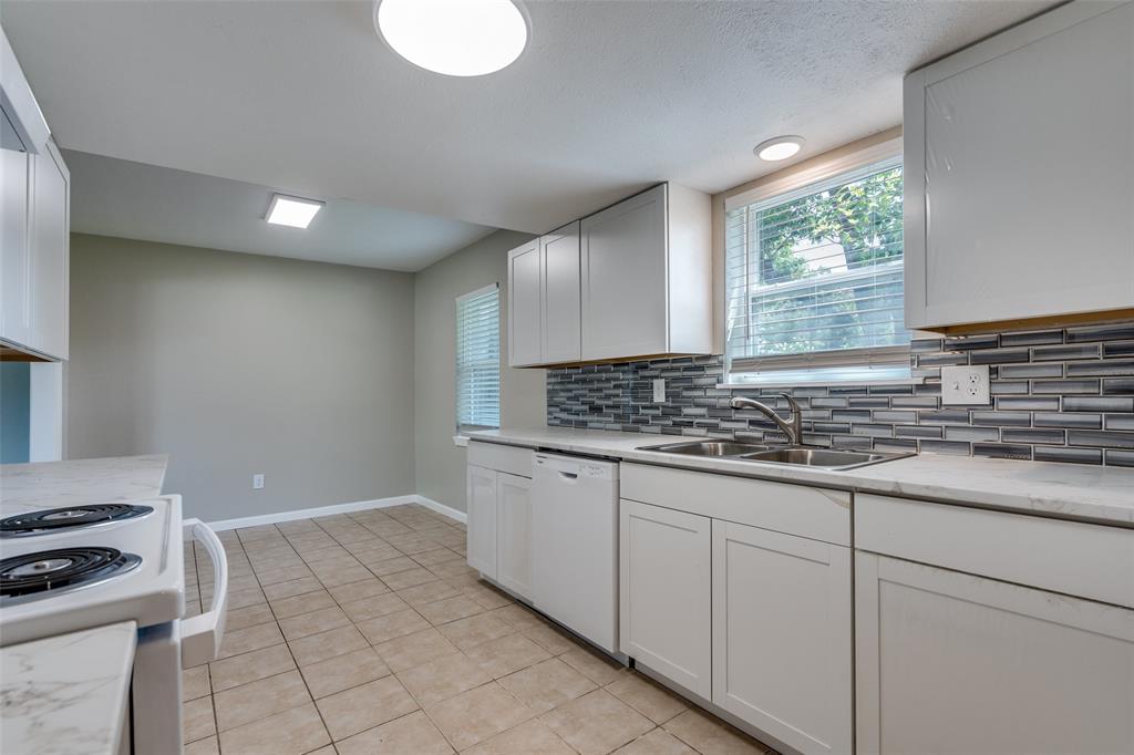 1202 Quill Drive Plano, TX 75075 - Photo 15 of 28 a kitchen with granite countertop a sink and a stove