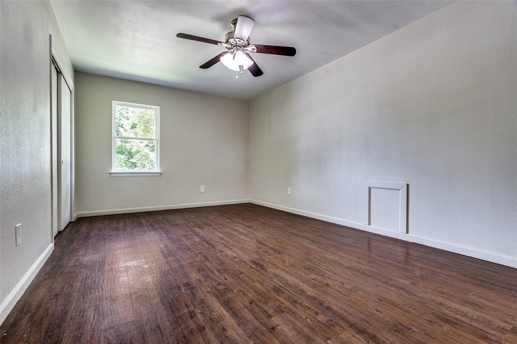 1202 Quill Drive Plano, TX 75075 - Photo 24 of 28 an empty room with wooden floor chandelier fan and windows