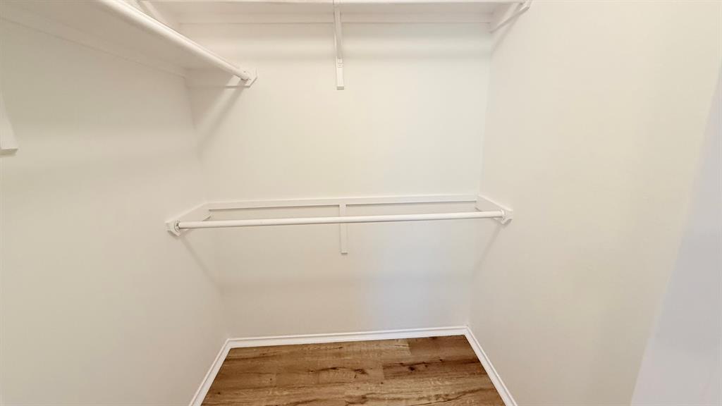 12259 Rim Rock Road Dallas, TX 75253 - Photo 13 of 17 Walk in closet featuring light wood-style floors