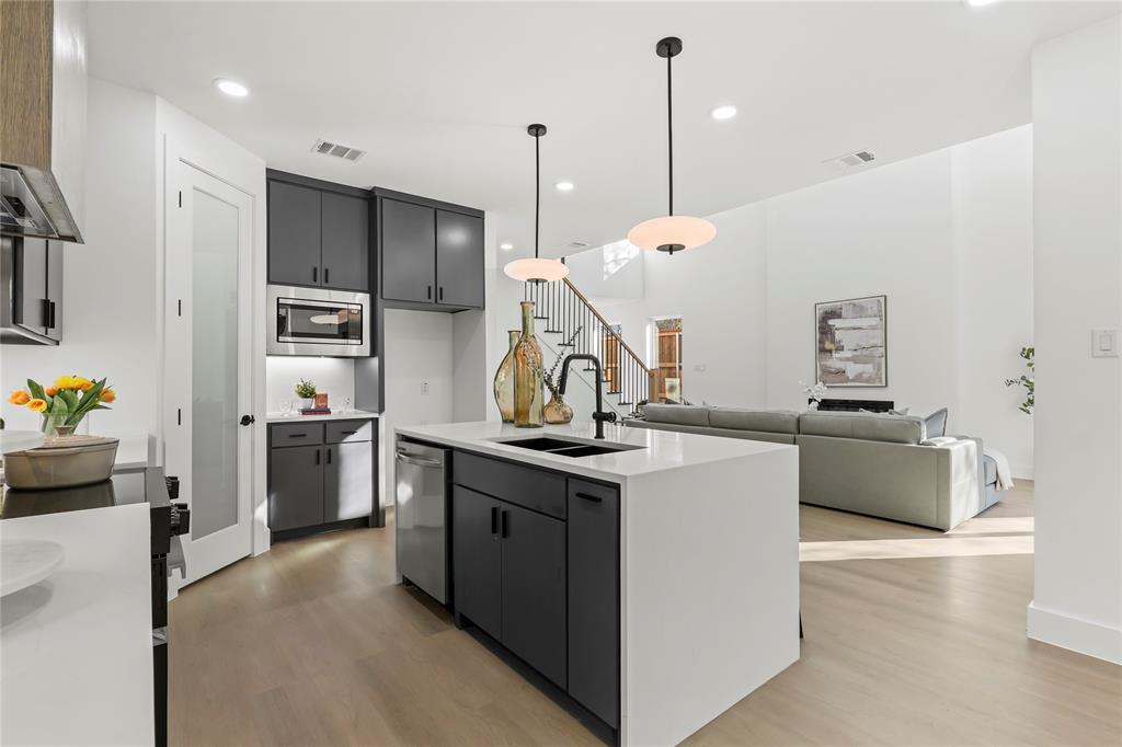 459 Hart Street Dallas, TX 75203 - Photo 21 of 21 Kitchen featuring a kitchen island with sink, pendant lighting, light wood finished floors, open floor plan, and recessed lighting