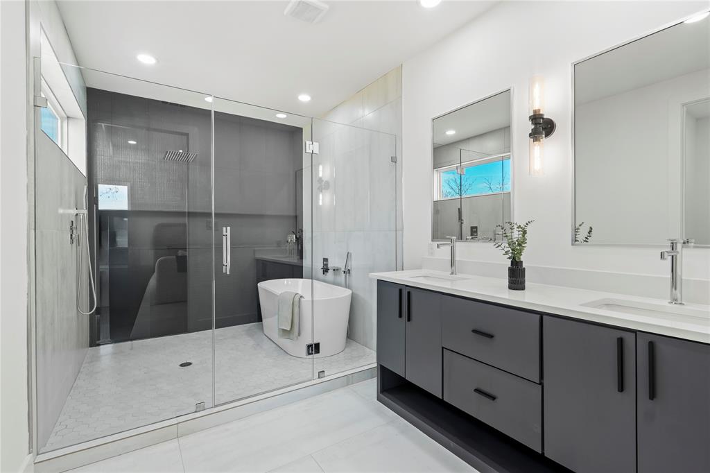 459 Hart Street Dallas, TX 75203 - Photo 16 of 21 Bathroom with double vanity, a stall shower, a freestanding bath, and light tile patterned floors