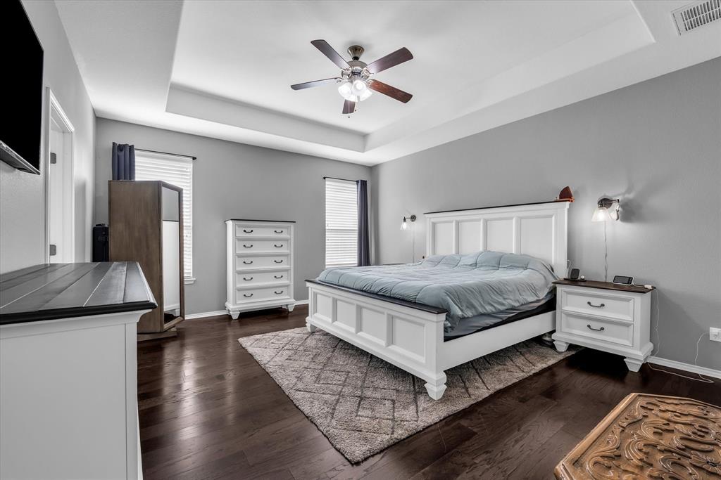 9453 Centennial Drive Waco, TX 76708 - Photo 18 of 37 a bedroom with a bed and dresser with wooden floor