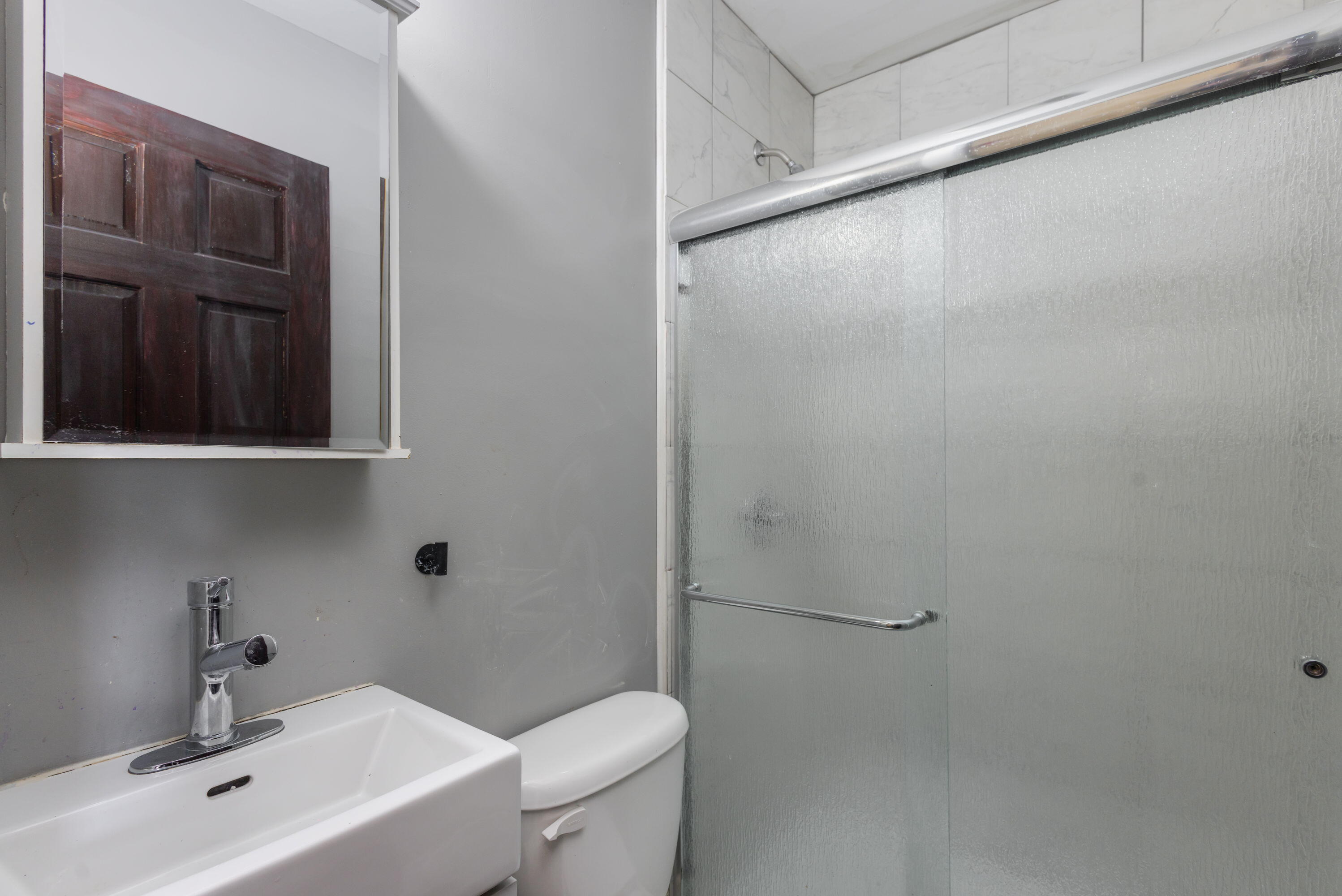 203 North Main Street Kingsbury, IN 46350 - Photo 22 of 32 a bathroom with a sink and mirror with toilet