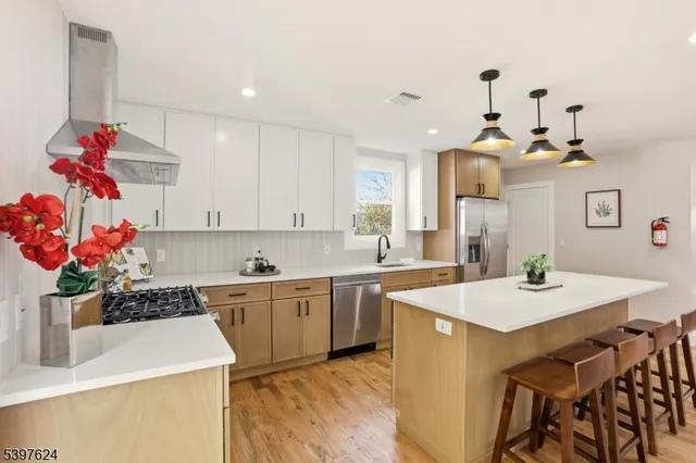 a kitchen with a sink a stove and white cabinets