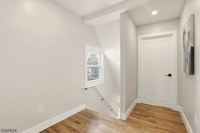 an empty room with wooden floor and a window