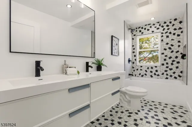 a bathroom with a sink toilet a mirror and shower