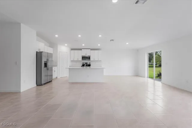 a kitchen with refrigerator a microwave a sink and cabinets